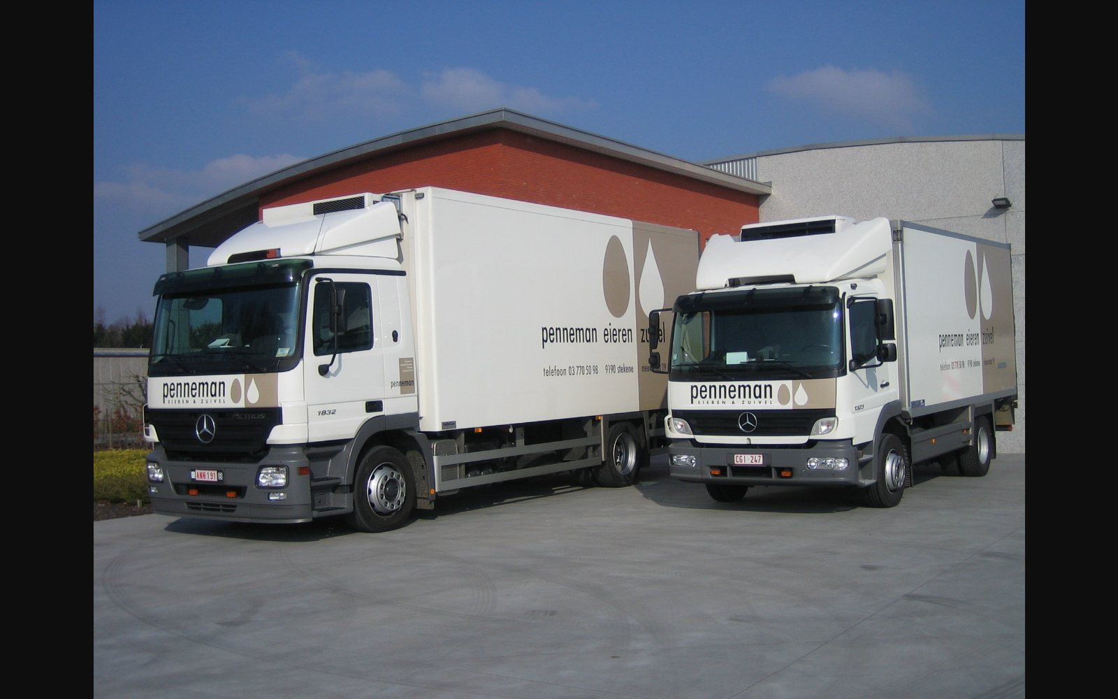 Koelwagens van Penneman voor het gebouw in Stekene